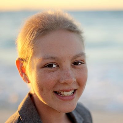 Headshot of a girl on a beach.